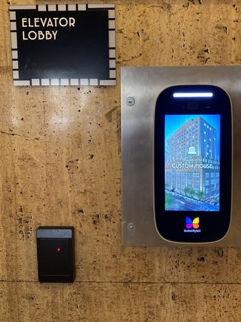 an iphone on a wooden floor next to an elevator lobby