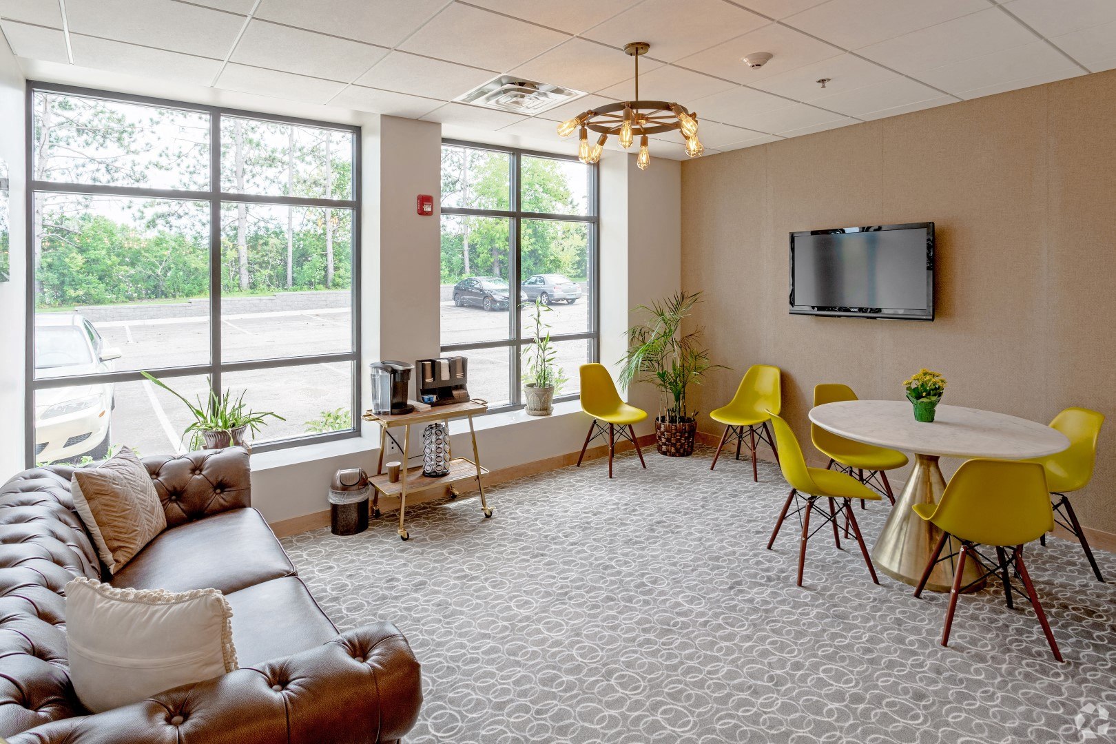 a living room with a couch table and chairs and a tv