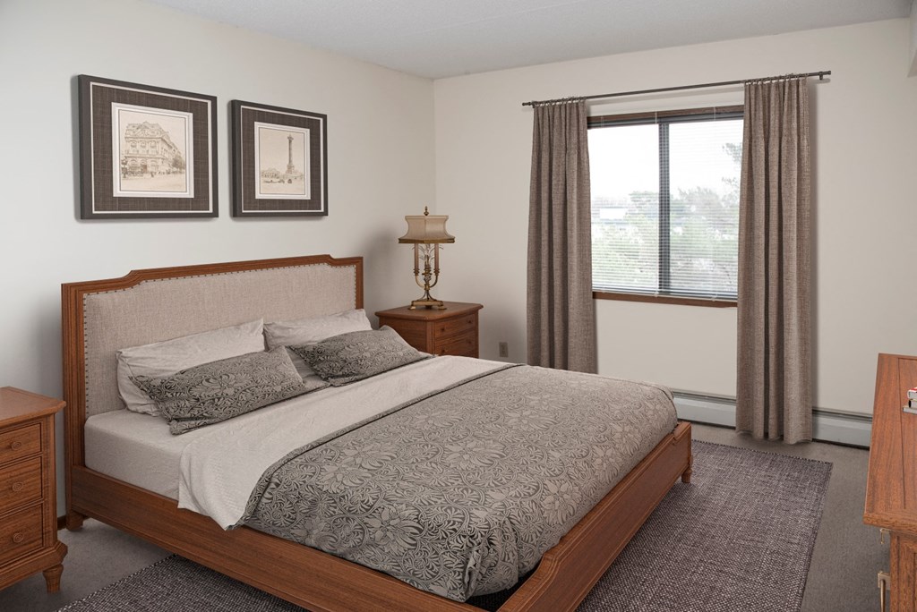 a bedroom with a bed and two windows