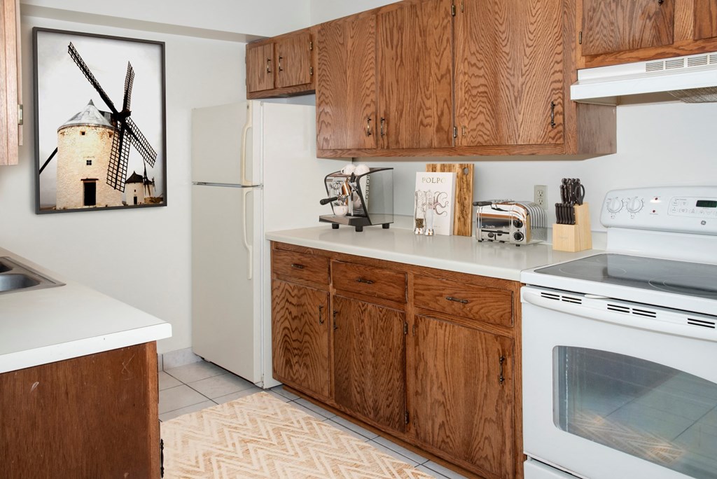 a kitchen with white appliances and wooden cabinets