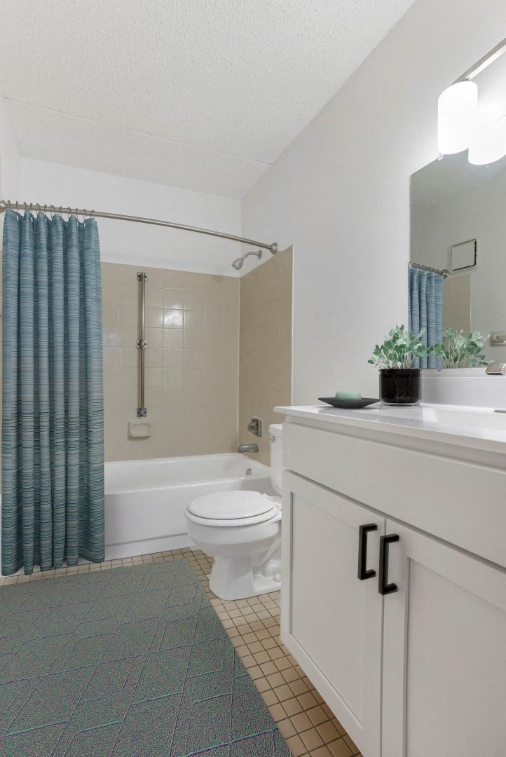a bathroom with a white toilet and a blue shower curtain