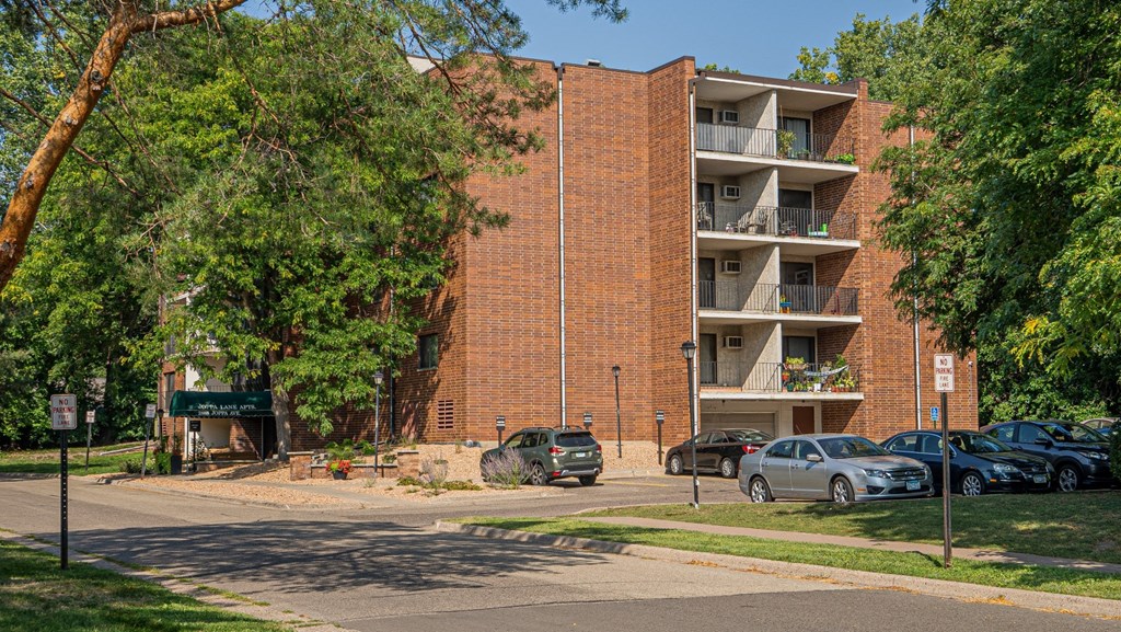 a large brick apartment building with cars parked in front