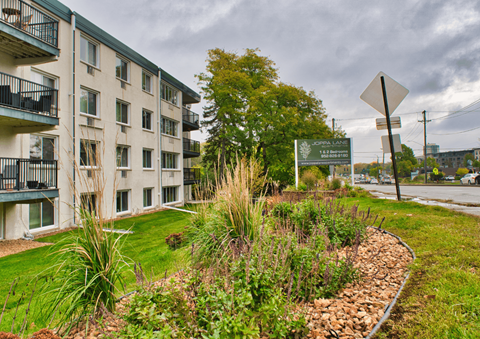A green sign is in front of a building.