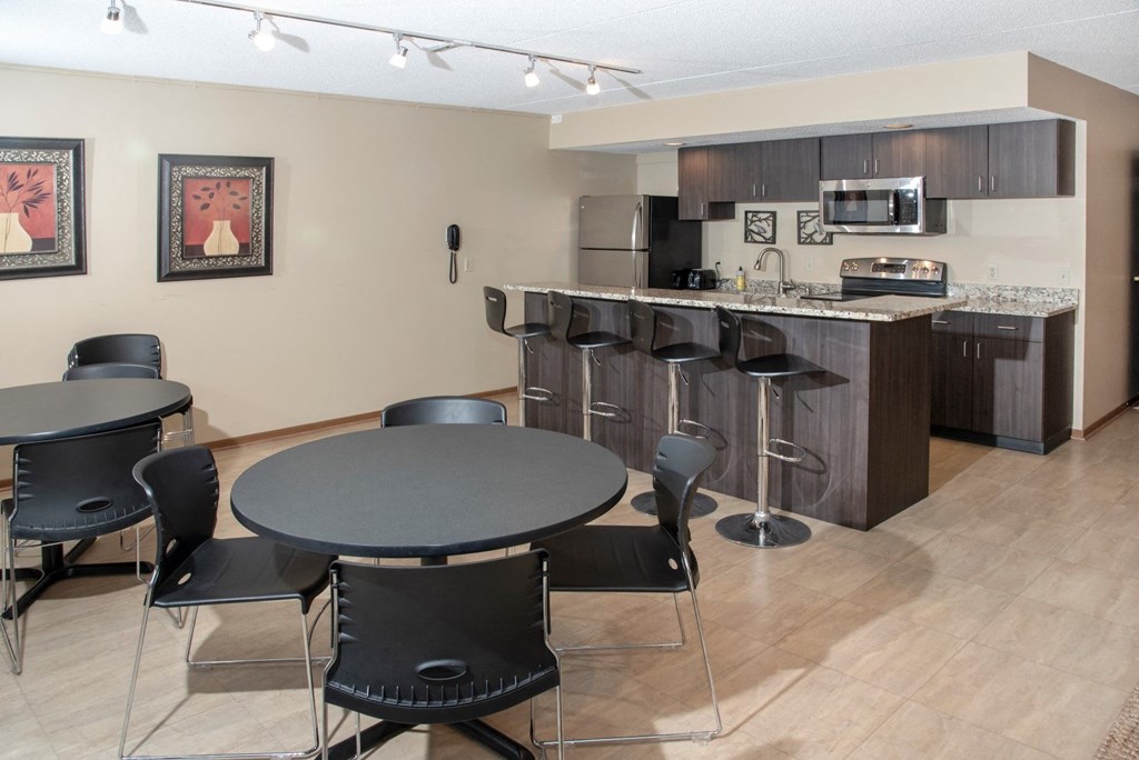 a dining room and kitchen with a table and chairs