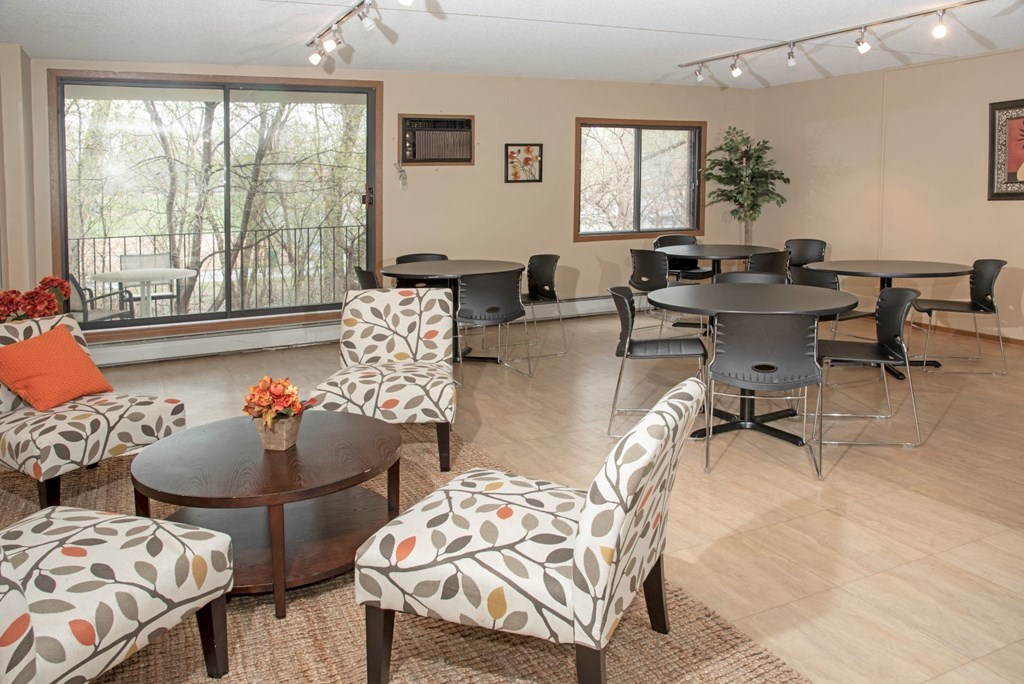a living room with tables and chairs and a large window