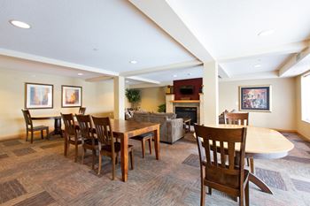 A living room with a fireplace and a dining table.
