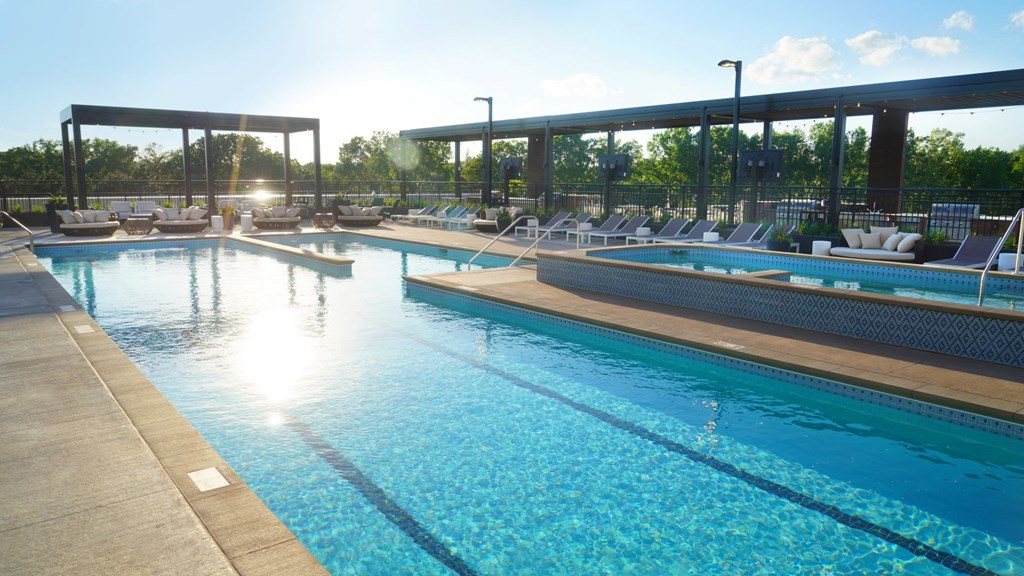 a resort style pool with lounge chairs and sun loungers