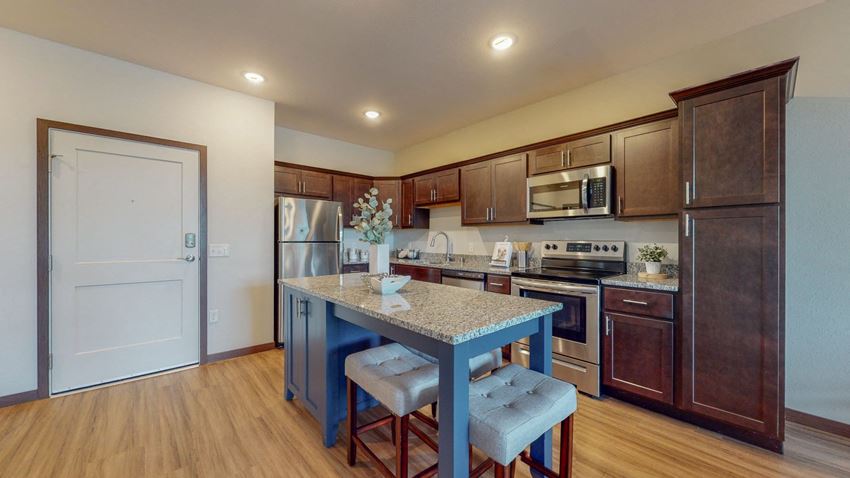a kitchen with a large blue island with two stools in front of it