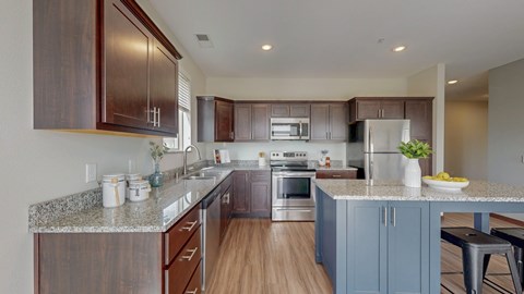 A kitchen with brown cabinets and a granite countertop.
