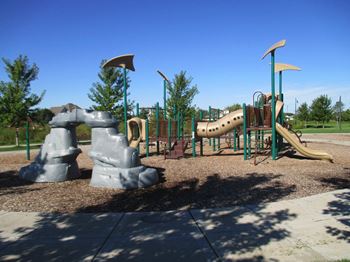 a playground with a slide and some large rocks