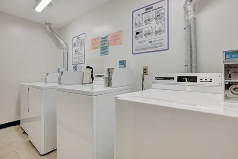 a laundry room with three washing machines and two sinks