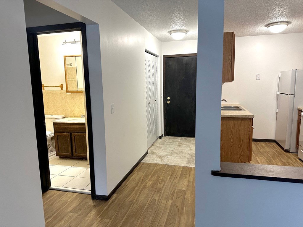 a view of a kitchen and a hallway with a door to a bathroom