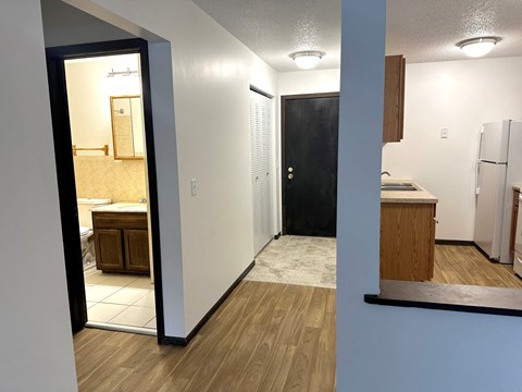a view of a kitchen and a hallway with a door to a bathroom