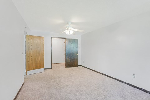 an empty room with white walls and a ceiling fan
