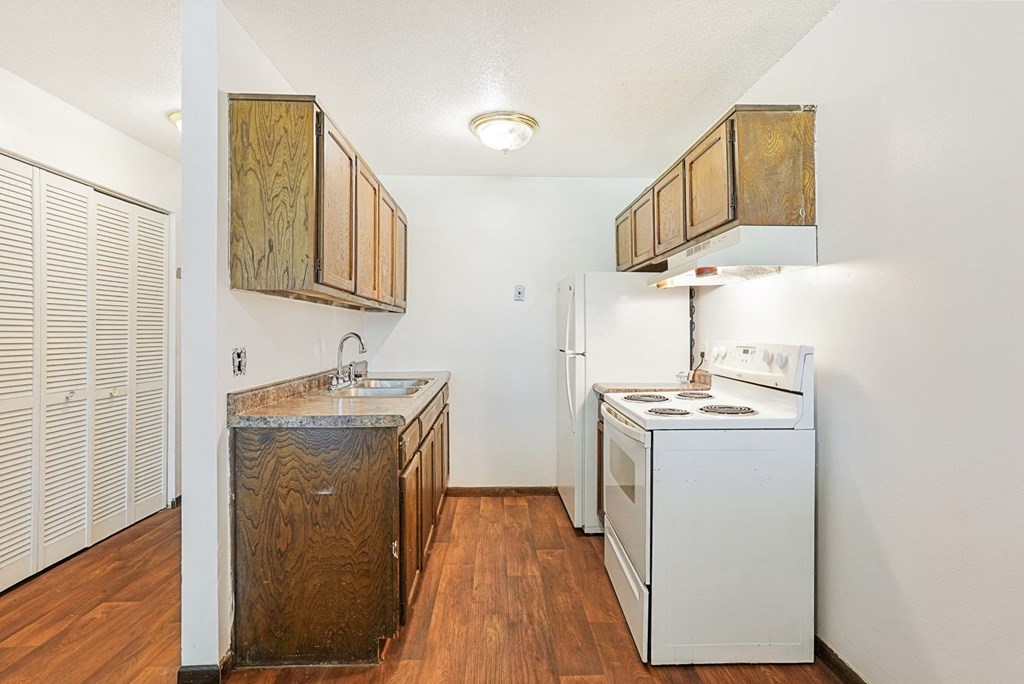 a kitchen with a stove refrigerator and a sink