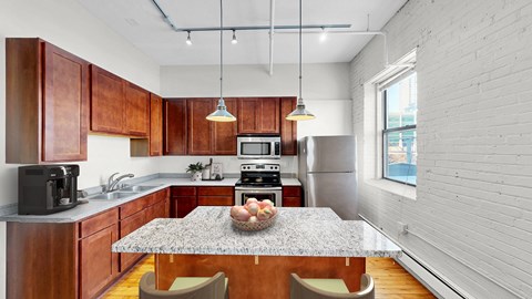A kitchen with wooden cabinets and a granite countertop.