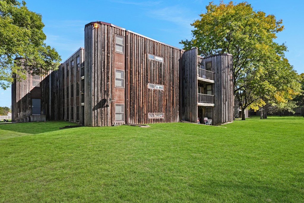 a building with a wooden facade on a green lawn