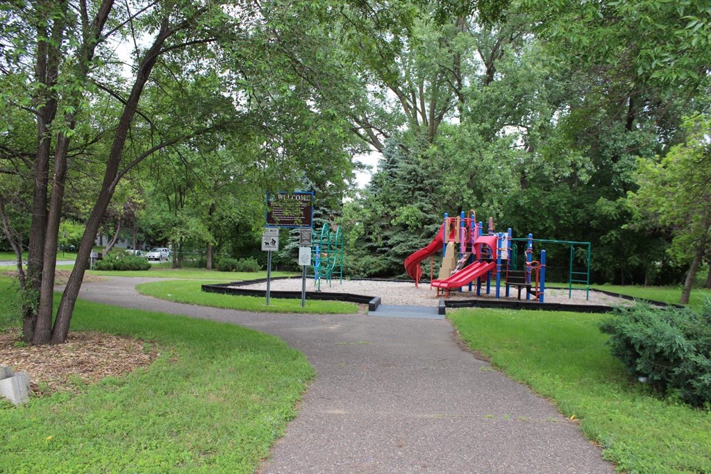 a park with a playground and a sidewalk