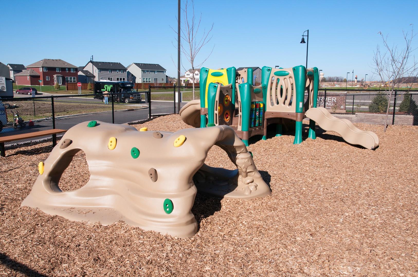 Playground Area with Wood-chips and Plastic Jungle Gym Sets at Carver Crossing Apartments