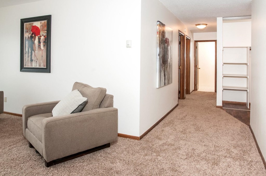 a living room with a couch and a hallway with a staircase