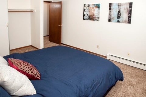 a bedroom with a blue bed and two pictures on the wall