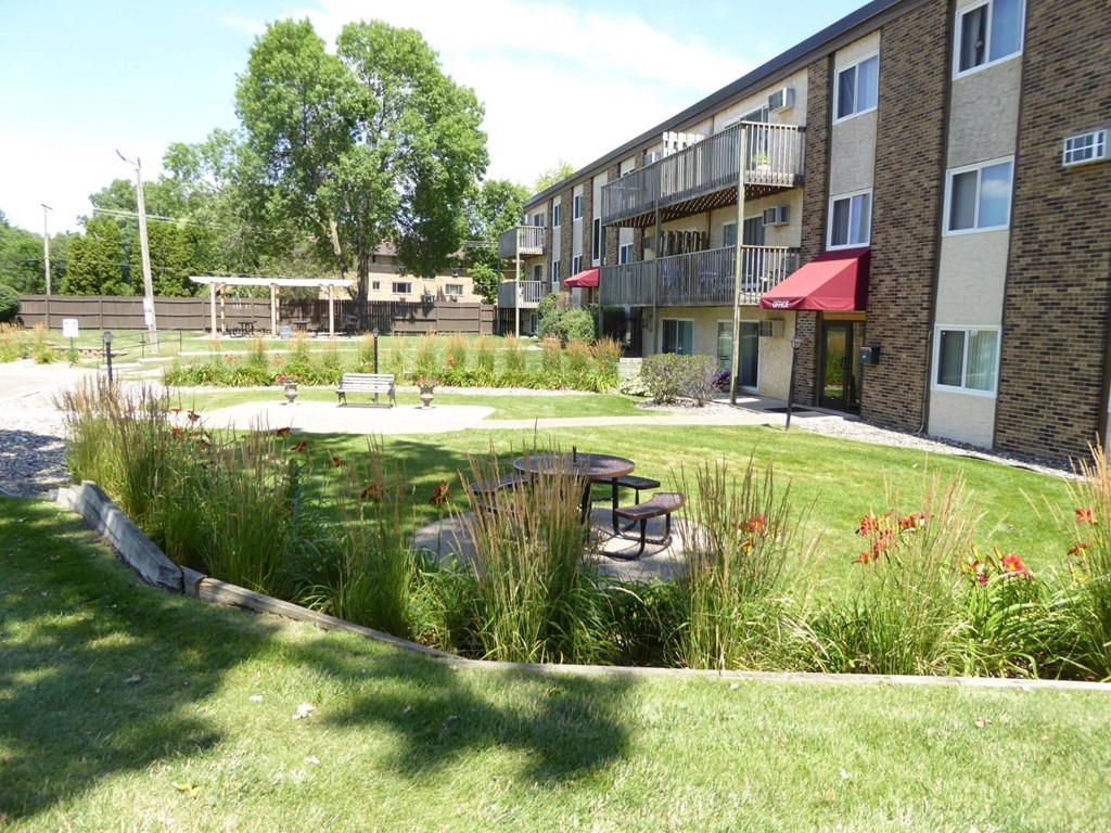 a courtyard with a picnic table in front of an apartment building