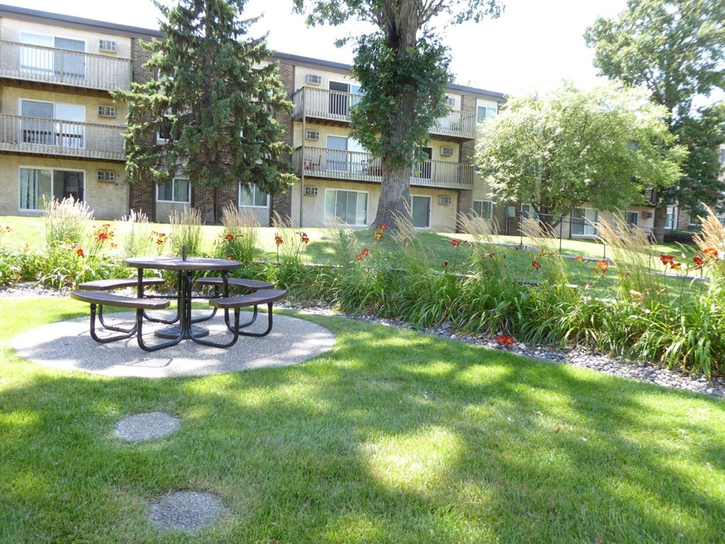 a courtyard with a picnic table in front of an apartment building