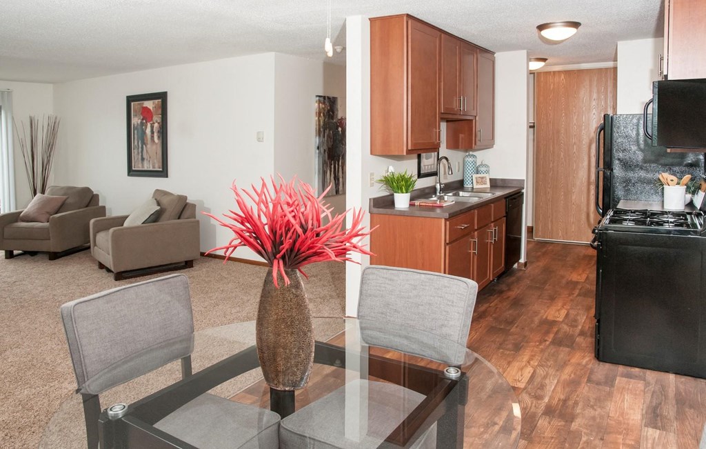 a living room and kitchen with a glass table