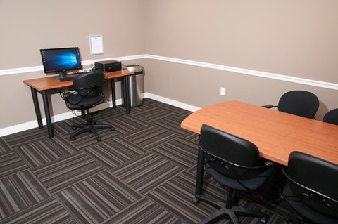 a conference room with two desks and a computer