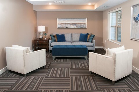 a living room with a blue couch and two white chairs