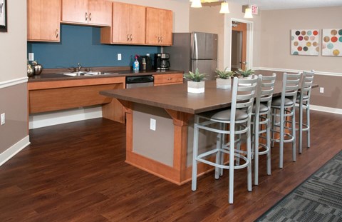 a kitchen with a bar and stools and a table with chairs