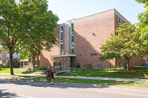 a person riding a bike in front of a brick building