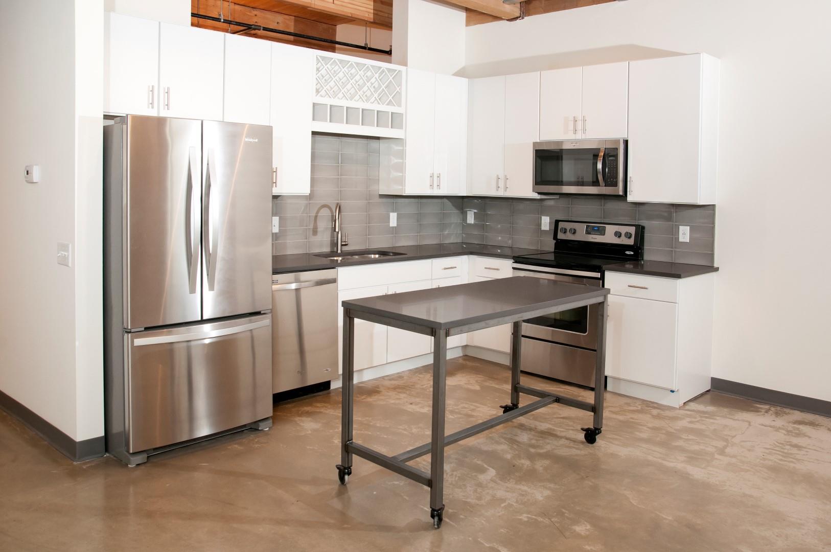 Kitchen with White Cabinetry, Stainless Steal Appliances and Movable Island at 700 Central Apartments, MN, 55414