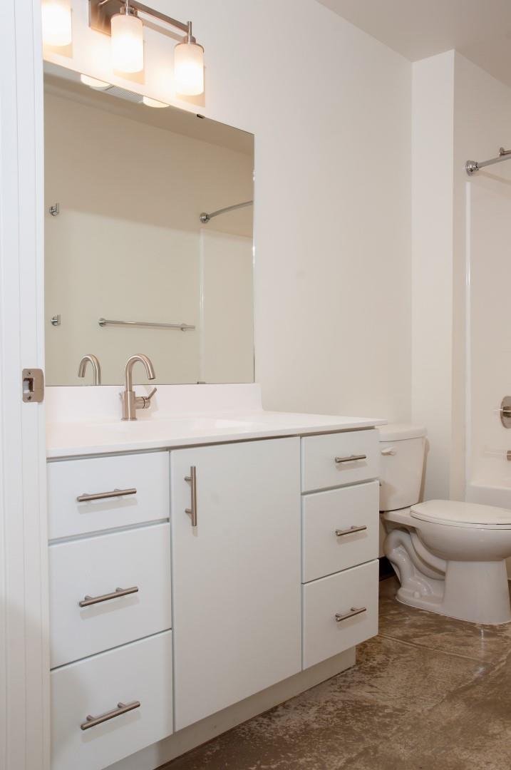 Spacious Bathroom with White Cabinetry and Silver Hardware at 700 Central Apartments, Minnesota, 55414