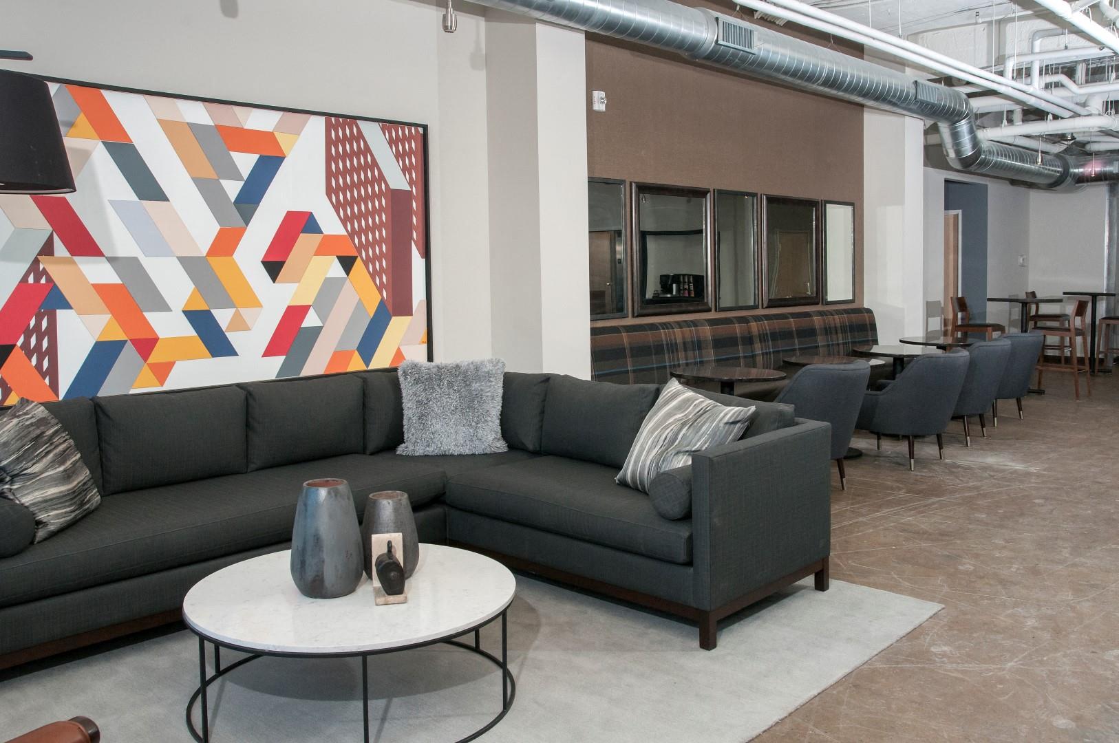 Large Industrial Style Lobby with Various Couches and Colorful Art at 700 Central Apartments in Minneapolis, MN