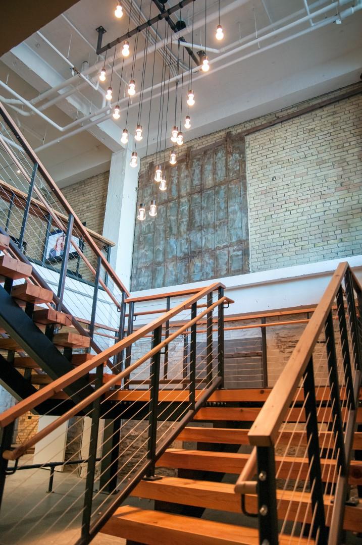 Chandelier Hanging Above Winding Wooden Stair Case at 700 Central Apartments, Minneapolis, MN