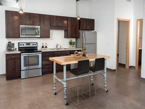 A kitchen with a table and chairs in the middle of it.