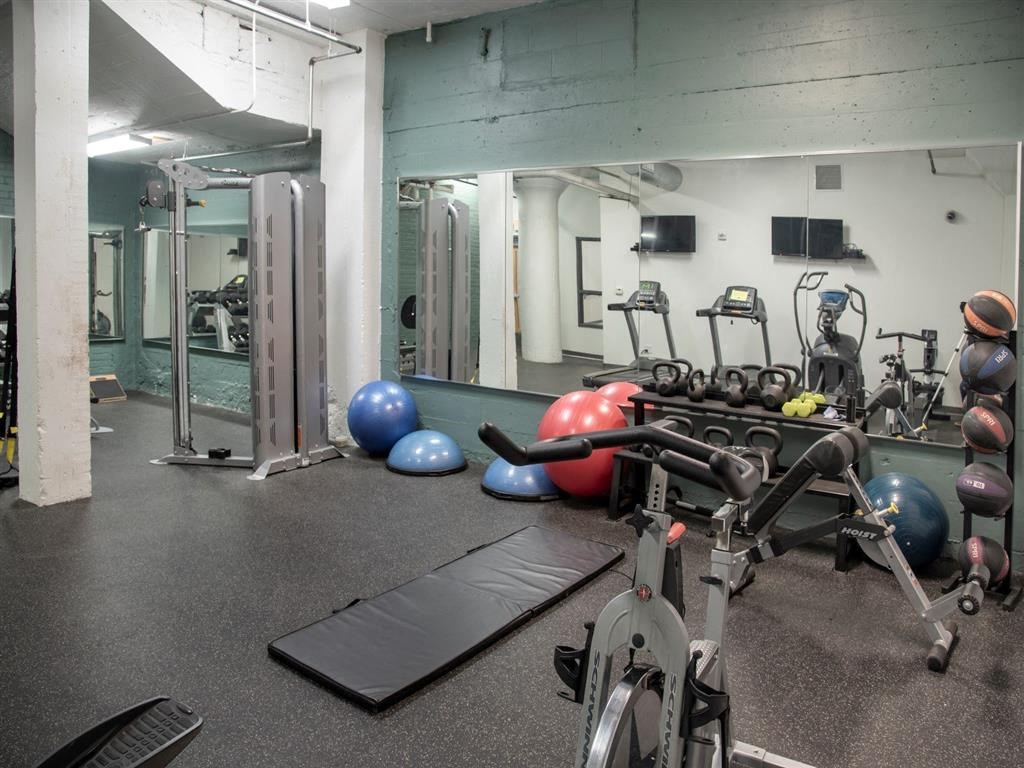 A gym with a variety of equipment including a treadmill, exercise balls, and weight machines.at Gurley Lofts, Minnesota