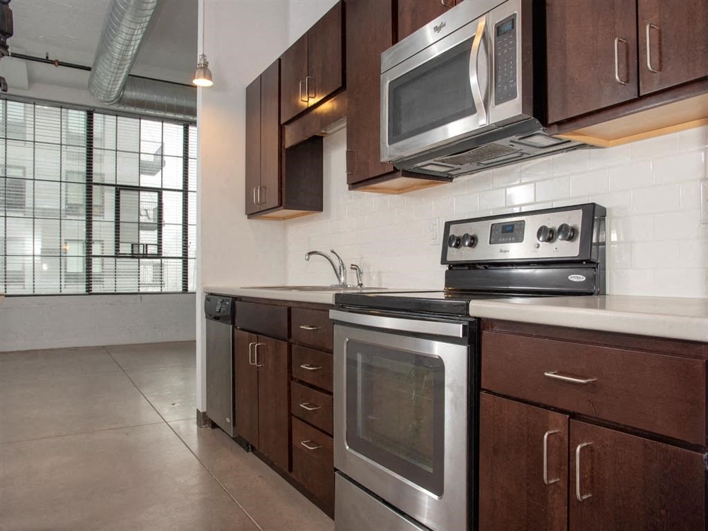 A kitchen with a stove, oven, and microwave.at Gurley Lofts, Minnesota