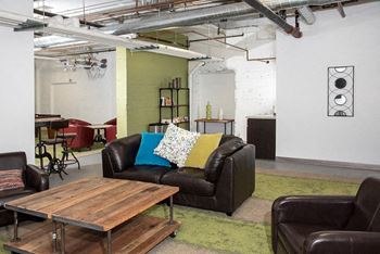 A living room with a black couch and a wooden coffee table.at Gurley Lofts, Minneapolis, MN