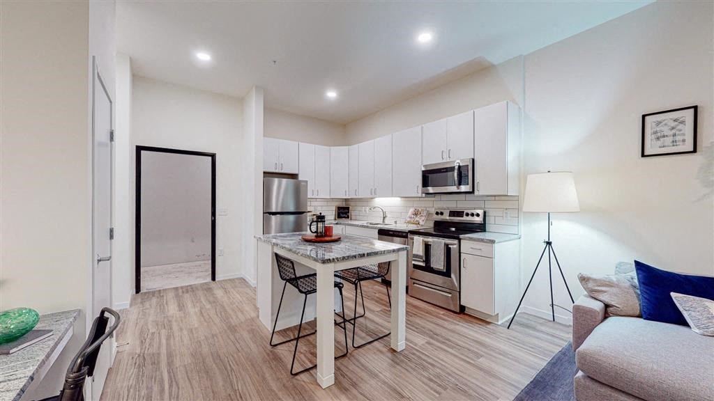 A modern kitchen with a dining table and chairs at The Bessemer at Seward Commons Apartments, Minneapolis, Minnesota