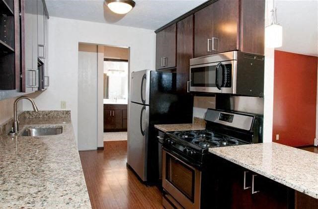 a kitchen with a stove and a refrigerator and a sink