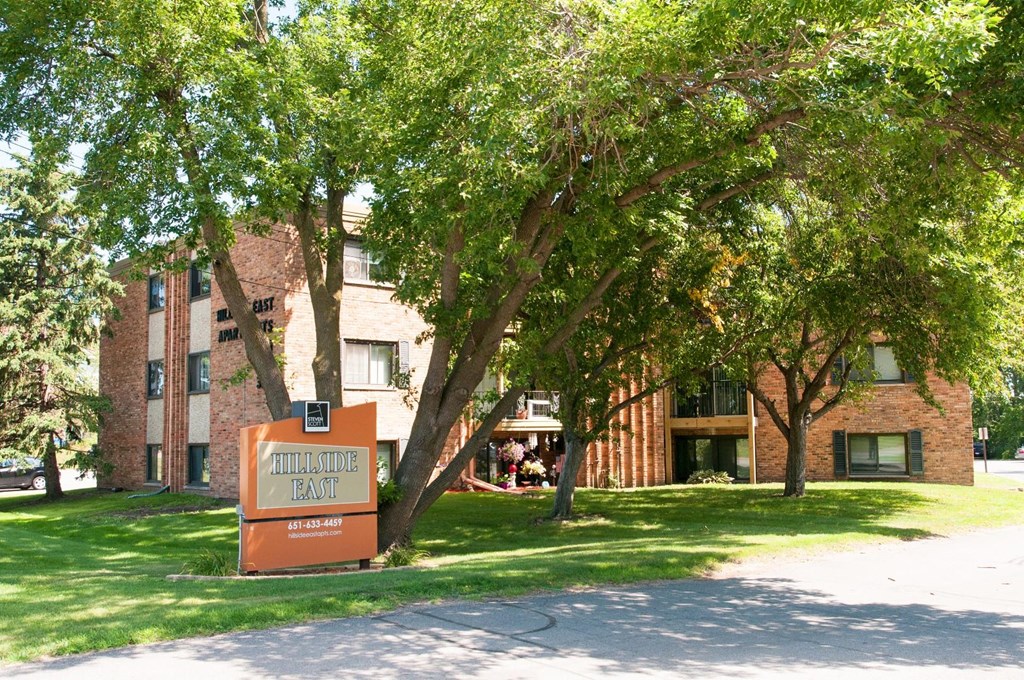 a large brick building with a sign in the grass