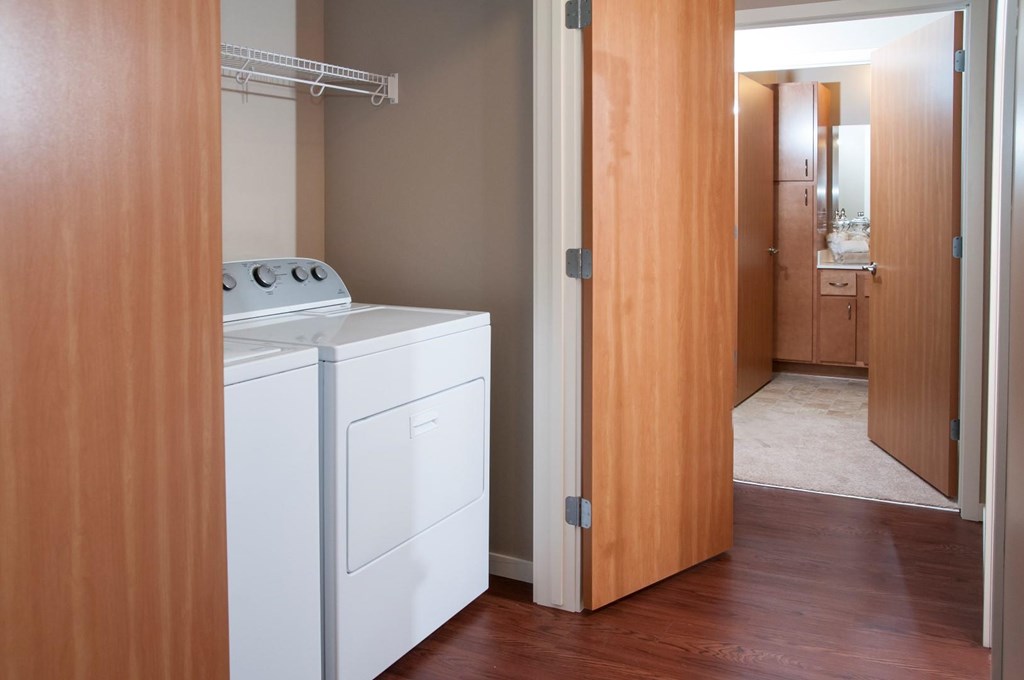 a laundry room with a washer and dryer and a door to a bathroom