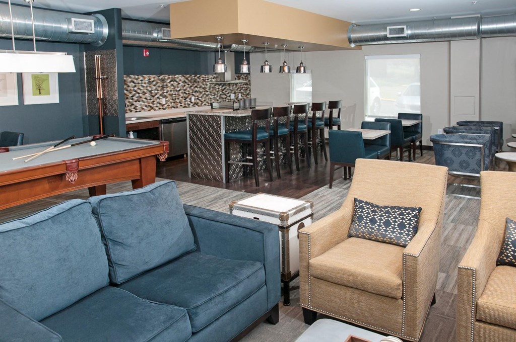 a clubhouse with a pool table and couches
