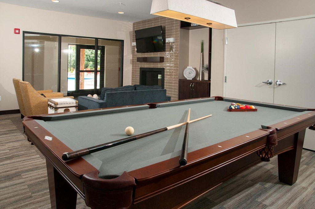 a pool table in a living room with a fireplace