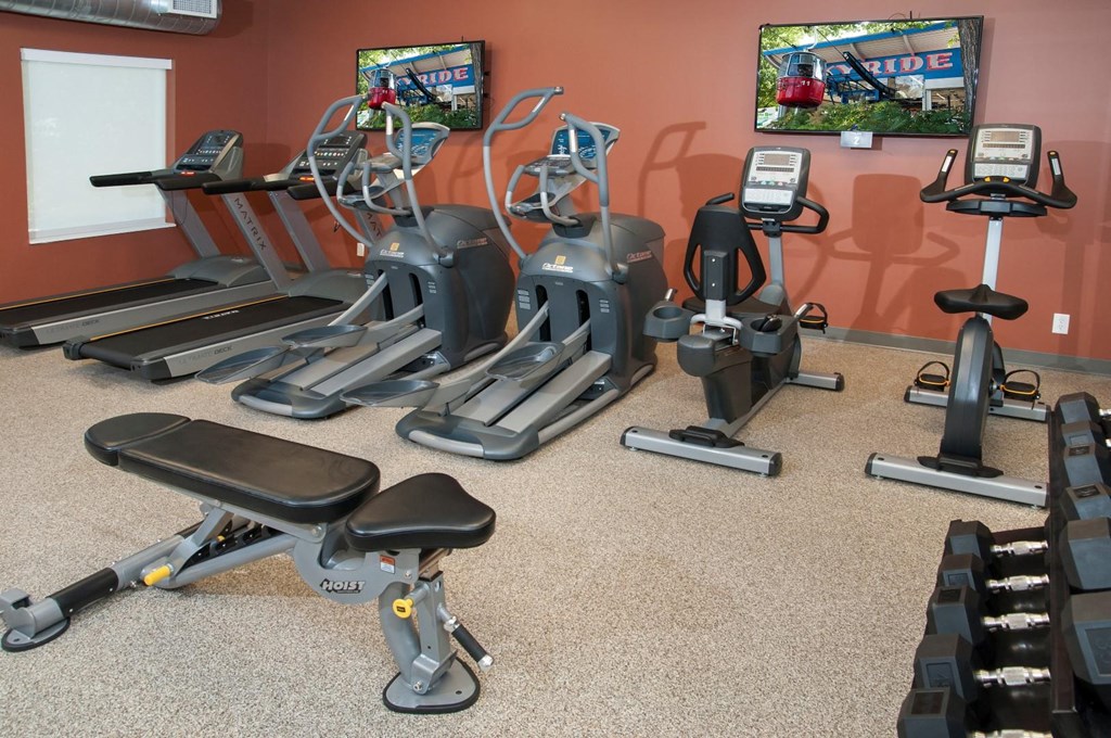 a gym with cardio equipment and televisions in a fitness center