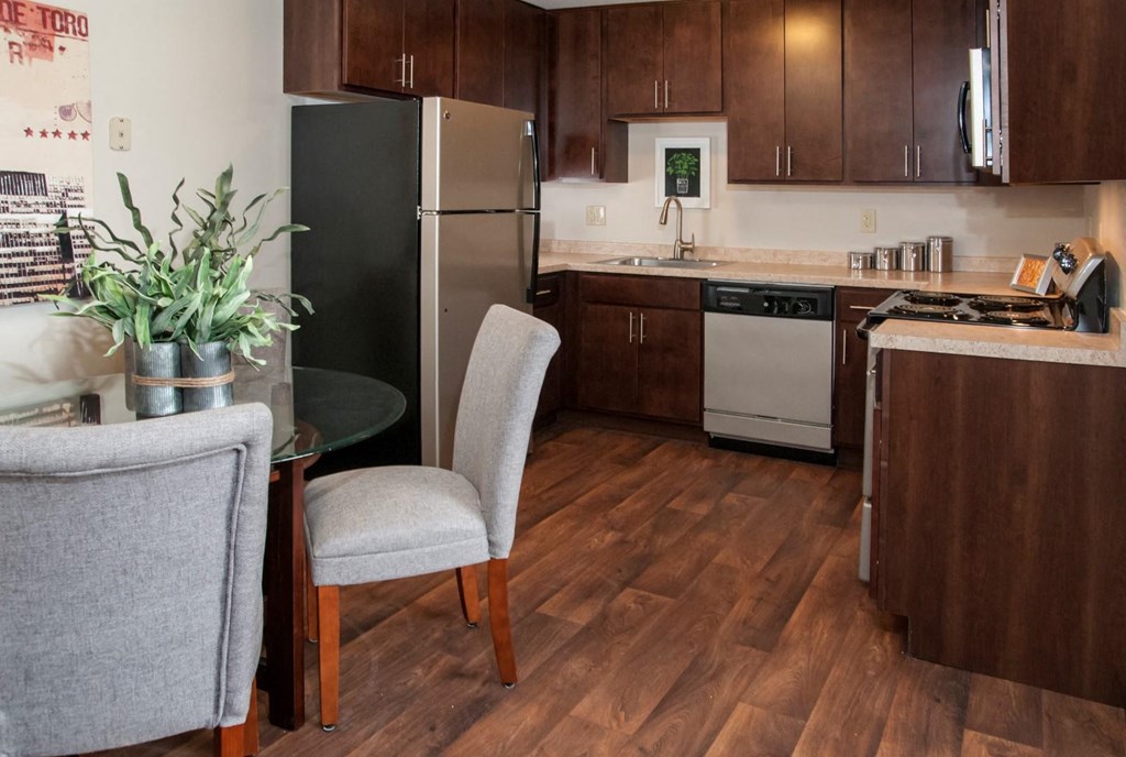 a kitchen with stainless steel appliances and a table with chairs