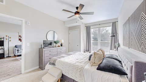 A bedroom with a large bed and a ceiling fan.