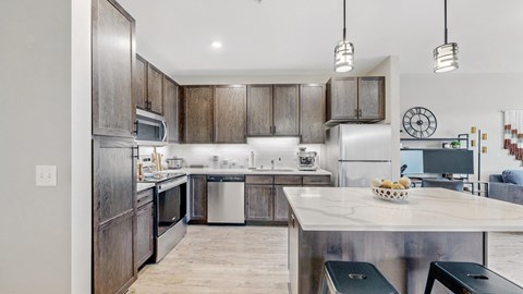 A modern kitchen with dark wood cabinets and stainless steel appliances.
